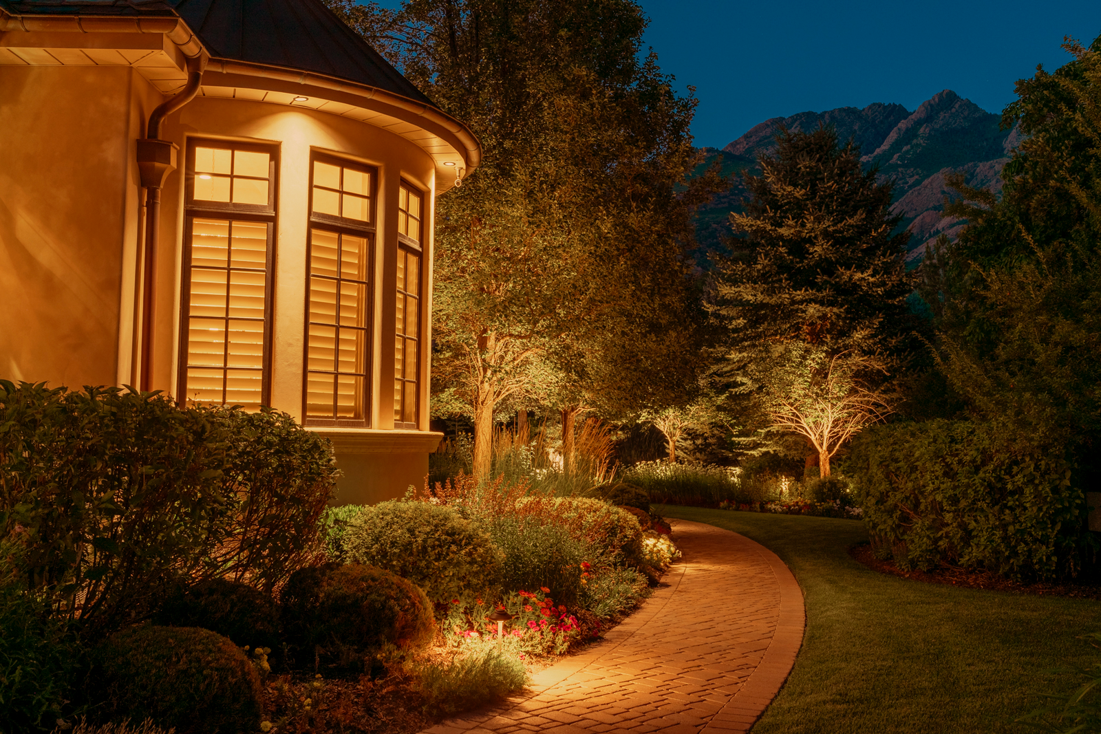 Outdoor landscape lighting illuminating a home at night